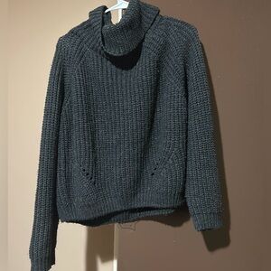It’s a dark grey turtleneck long sleeve sweater